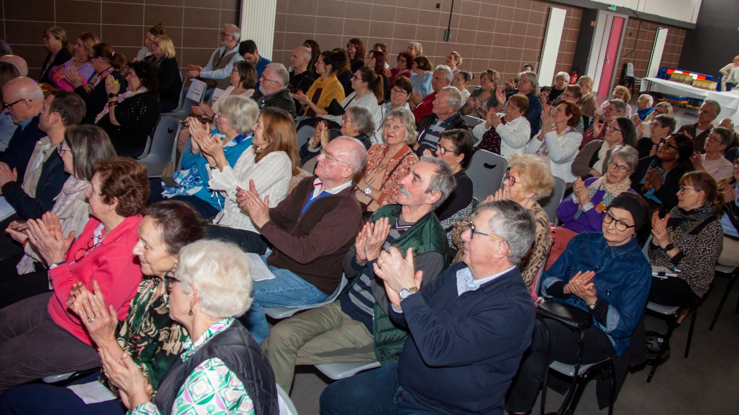 Participants applaudissant lors de l’assemblée générale Ludopital du 6 mars 2026