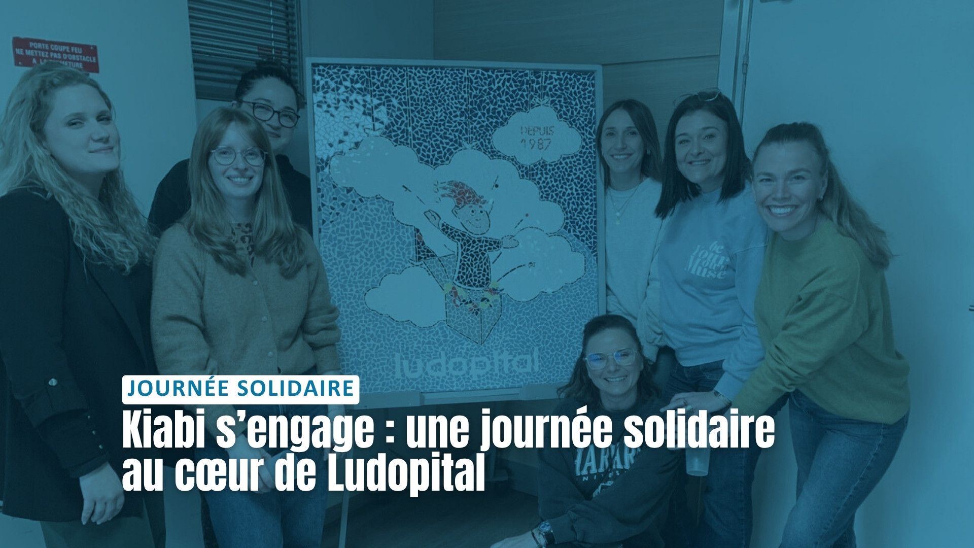 Groupe de collaboratrices Kiabi posant devant les locaux de Ludopital avec la mosaïque du logo de l’association lors de leur journée solidaire